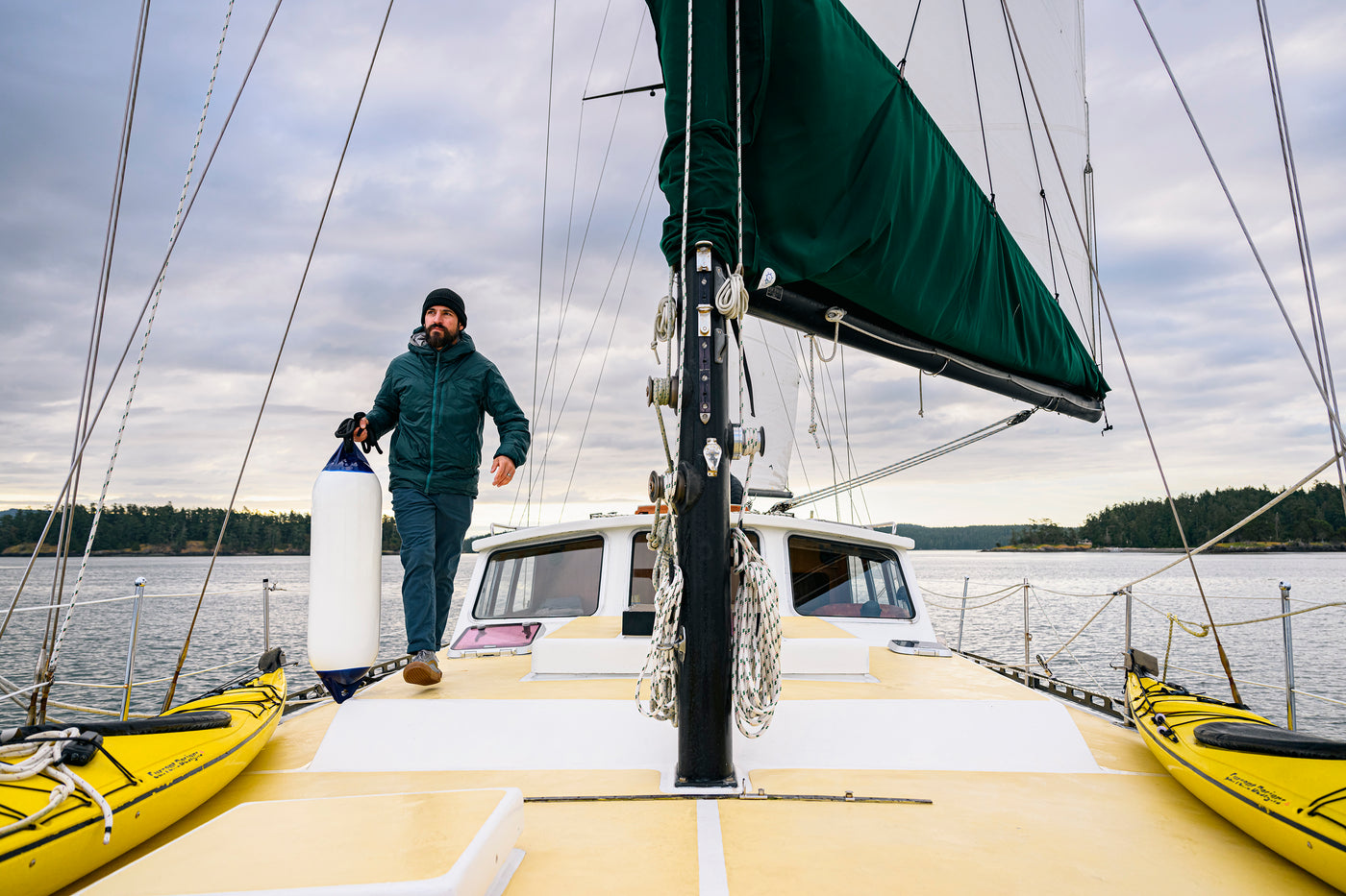 Man walking with a boat fender on a sailboat 