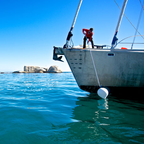 Mooring buoy retrieval by crew member using mooring hook on boat in South Africa