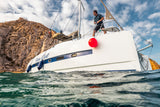 Boat fenders and inflatable buoy on yacht approaching a rocky mooring in Baja, Mexico